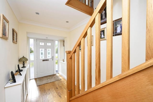 As we prepare to go upstairs, let's pass through the welcoming entrance hallway, which has oak flooring and spotlights to the ceiling. An oak staircase guides us to the first floor.