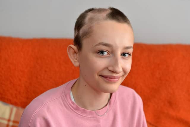Ella Goodwin, 13, seen with parents Shaun and Joanne has lost her hair due to illness. She doesn't want to wear a wig but is being told she cannot wear a cap to school.