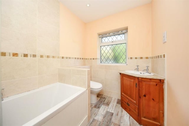The bathroom in Foxglove Cottage contains a bath, a corner wash basin set in a vanity unit and a wc.