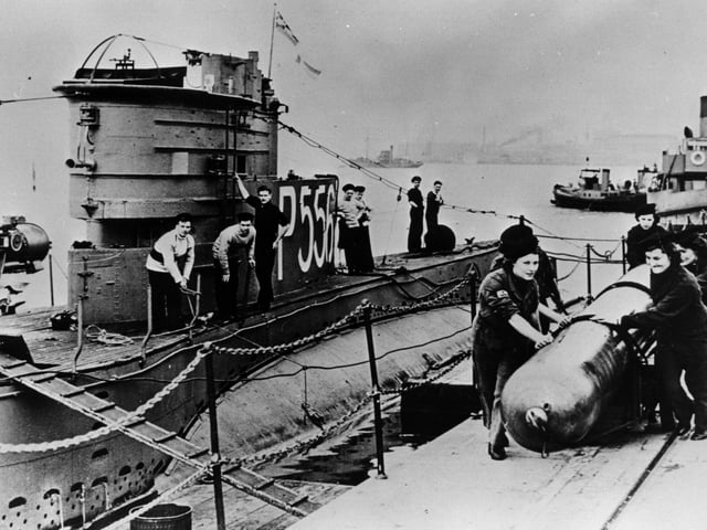 World War II Wrens loading a torpedo onto a submarine at HMS Dolphin, Gosport. The News PP5376