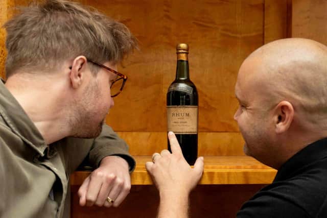 Hansons Auctioneers’ experts Jim Spencer (L) and Stuart Palmer (R) examine the bottle.  Photo: Emma Errington / Hansons / SWNS