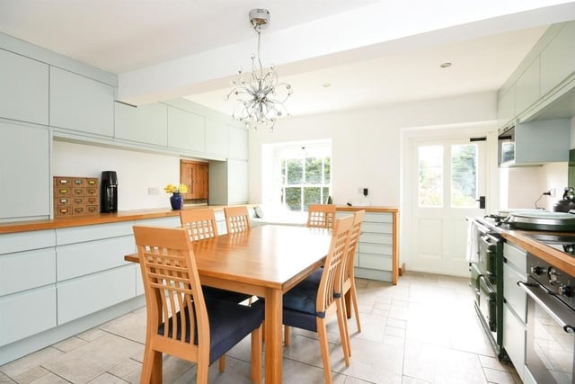 The farmhouse kitchen has an Aga cooker, wall, base and drawer units and an original serving hatch. There is a window seat and ample space for a dining table.