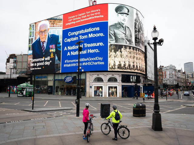 An hourly salute to Captain Tom the army veteran in Piccadilly Circus, London. 99-year-old war veteran Captain Tom Moore's challenge to raise money for NHS charities to walk 100 laps of his garden before his 100th birthday has hit £20 million, less than two weeks after he began the challenge. He completed his 100 laps on Thursday.
