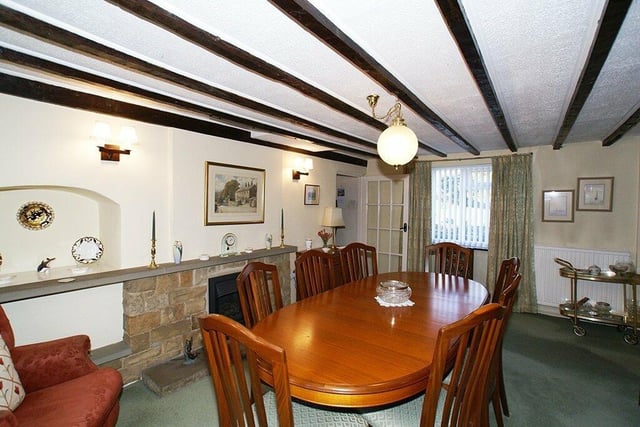The dining room has exposed beams to the ceiling and its rear window is set in original stone mullions. A fireplace with dressed stone surround houses a gas fire.