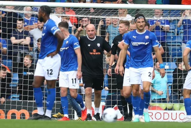 Paul Cook wenton the pitch to protect his players after Oldham fans invaded the pitch. Image: Tina Jenner.