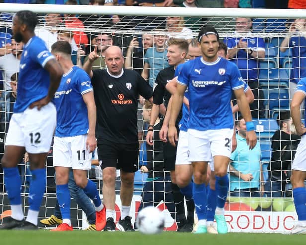 Paul Cook wenton the pitch to protect his players after Oldham fans invaded the pitch. Image: Tina Jenner.
