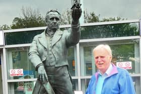 Dr Peter Broughton with his George Stephenson Medal by the statue outside Chesterfield railway station.
