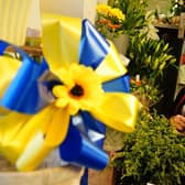 Marie Carline, owner of Bolsover Flowers, with one of her sunflower bows to help the people of Ukraine. Picture by Brian Eyre.