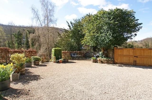 Oak wooden entrance gates open to a spacious area of enclosed garden and gravelled driveway providing parking for several vehicles.  Extending from the drive is a further gravelled area with ample space for garden furniture, a barbecue and pot plants.