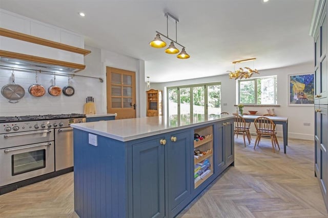 The island kitchen is fitted with solid oak units, has integrated appliances and flows through to the dining area where doors lead onto the rear garden.
