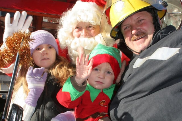 Maisie Lawrence, 8, with Owen Blake, 3, and grandad firefighter Owen Moran on Santa's fire engine outside Chesterfield Co-op in 2006.
