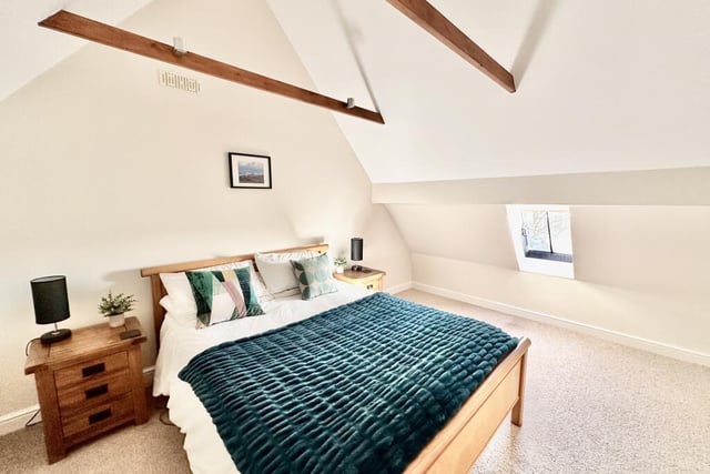 The master bedroom with vaulted ceiling has a dressing room and ensuite shower room.