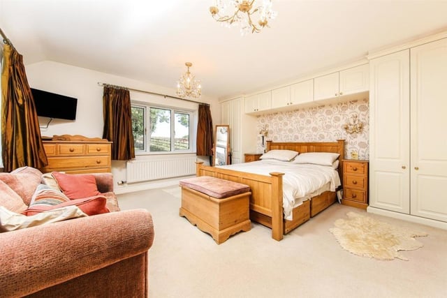 The spacious master bedroom has fitted wardrobes and  enjoys views across the large landscaped garden from one of two windows.