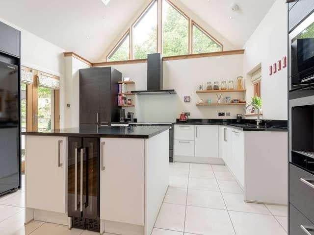 The modern kitchen has an island for storage and is bright and airy.