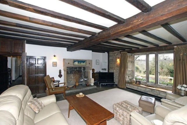 The drawing room looks out over the garden, paddock and wooded hills that surround the area. This room has a stone flag floor, original oak ceiling beams, and an  oak panelled wall. There is a large fire opening with a dressed stone surround, heavy corbelled lintel and raised hearth.  A musket loop window is at the side of the fireplace. The room is illuminated by wall lamps with wrought iron sconces, which are also found in most rooms.