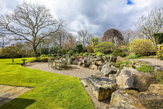 A rockery and gravelled seating area within the expanse of garden.
