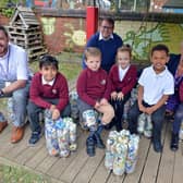 Tibshelf Infant and Nursery School headteacher Zoe Andrews with Bolsover MP Mark Fletcher, County Councillor James Barron and Year 1 and 2 pupils with their eco bricks in the outdoor area