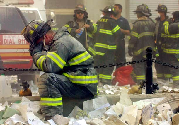 Firefighter Gerard McGibbon, of Engine 283 in Brownsville, Brooklyn, prays after the World Trade Center buildings collapsed September 11. (Photo by Mario Tama/Getty Images)