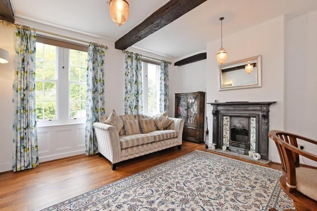 An open fireplace, beams and sash windows draw the eye in this elegant room.