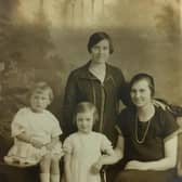 Christine Lilian Metcalf,  standing centre, aged six in 1926. Cousin Brenda is sitting on the table. Christine's mum, Lilian Holt, is standing and Aunty Poll is right.
