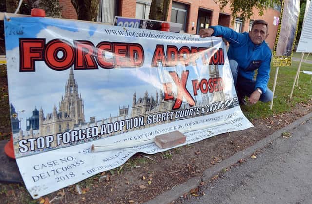 Paul Johnson is protesting against what he calls 'forced adoption' for the third year running outside North East Derbyshire Social Services building in Clay cross.
