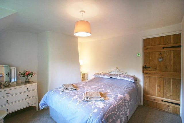 A lovely wooden door with latch adds to the charm of this double bedroom.