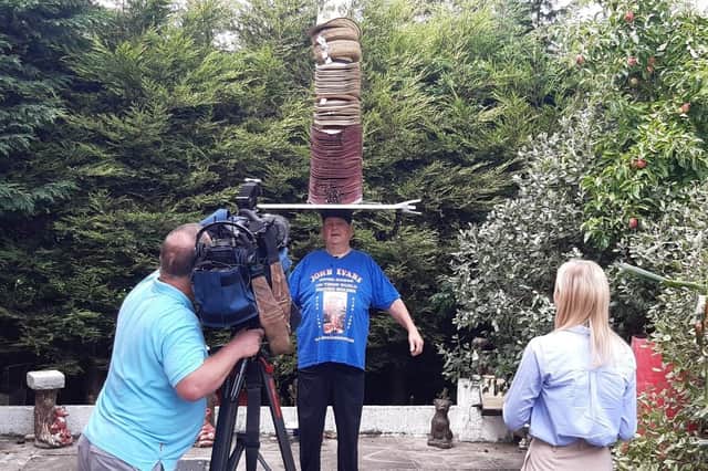 John Evans' latest head-balancing world record is filmed by a TV crew.