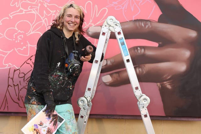 Peachzz looking happy with how her mural was turning out.