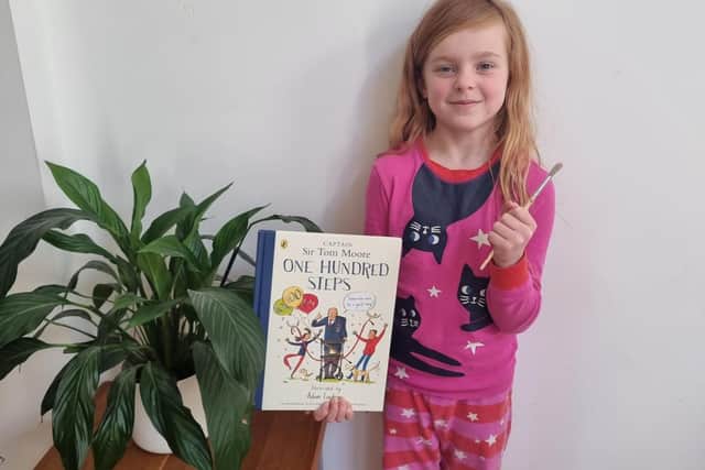Thea holding the book that inspired her.