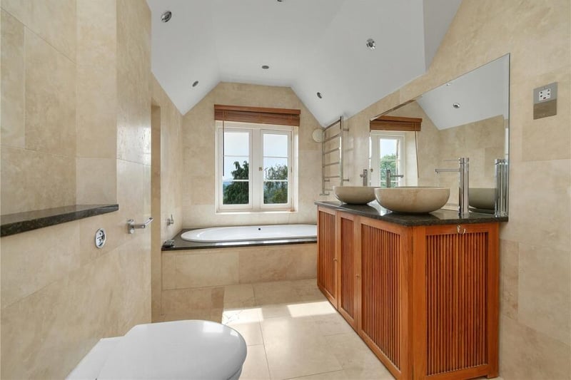 The en-suite which serves the principal bedroom has dual travertine sinks on a granite top, a jacuzzi bath and a double walk-in shower with built in Tile Vision television.