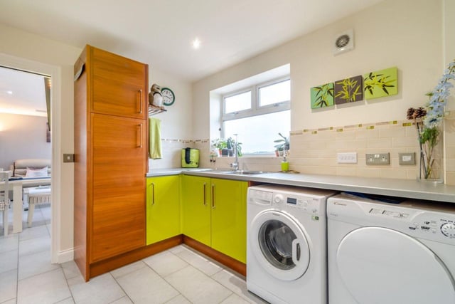 A neatly designed utility room complements the kitchen.