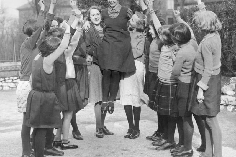 14 year-old Buxton schoolgirl Peggy Mycock is cheered by her friends for being chosen as the 1934 Festival Queen of Buxton, Derbyshire. She was selected out of 30 girls from local elementary schools, and will be crowned during 'Well Dressing Week' in June.