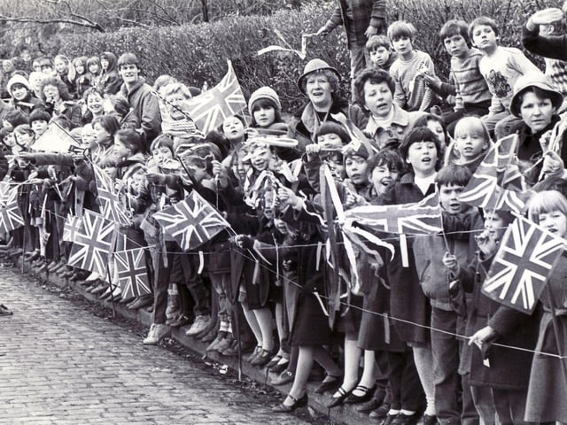 Flag waving children cheer the Queen as she arrives at Matlock Railway Station, on March 15th 1985.