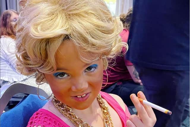 Phoebe Edwards, aged seven, has been a super fan of the comedy sitcom 'Benidorm' since she was five. Pictured here with a fake cigarette - a prop for her to be in character as Madge.