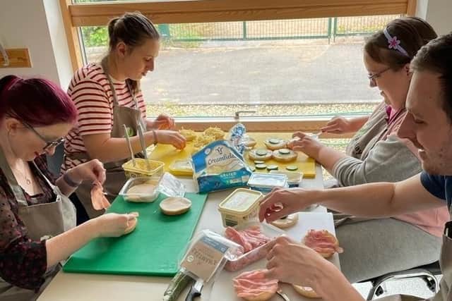 Members of Fairplay's Enterprise group prepare sandwiches for afternoon tea.