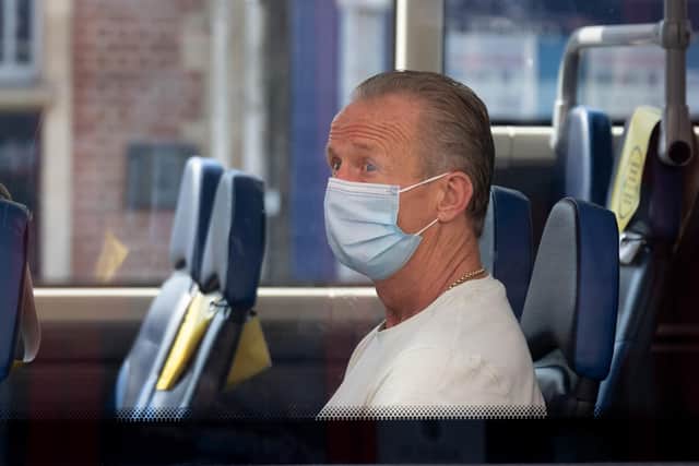 : A man wears a surgical face mask on a bus (Photo by Matthew Horwood/Getty Images)