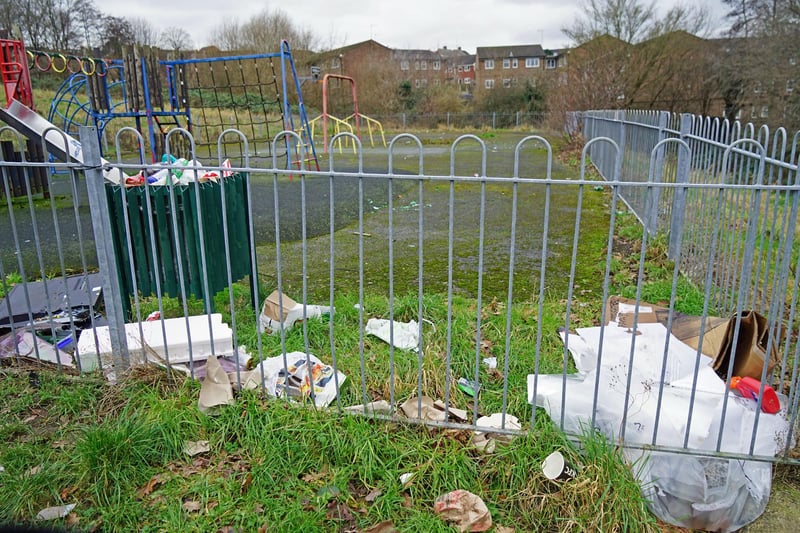 The play area bins are surrounded by litter.