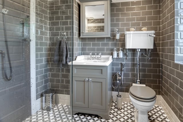 The period bathroom suite includes a double shower cubicle with rainfall shower head, vanity wash basin and wc. Stylish tiled wall and floor coverings and modern fittings complement the room.