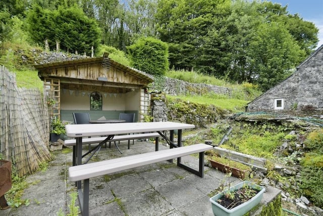 There is a covered seating area to the side of the property and a tiered garden at the rear.
