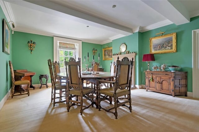 The formal dining room has a window seat and an open fire with stone surround.