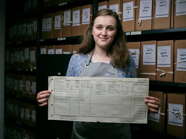 Emily Briffett, a Findmypast conservation technician,  holds the 1921 Census return for Thomas Moore, better known as Sir Captain Tom, who famously walked 100 laps of his garden during the pandemic and raised £33m for NHS charities. At the time the Census was taken Tom was 1 years old and living in Keighley (photo: Mikael Buck/Find My Past/The National Archives)