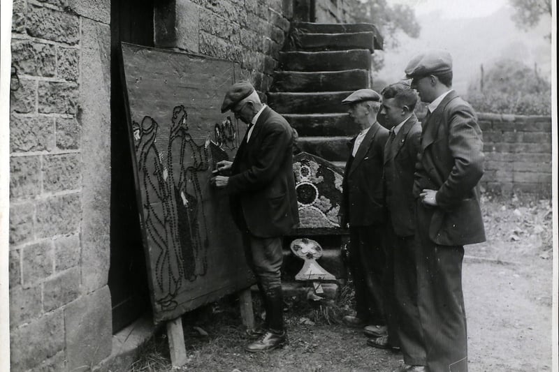 Dressing the well at Youlgreave. One of the well-dressers demonstrating to other villagers. (Photo by Hulton Archive/Getty Images)