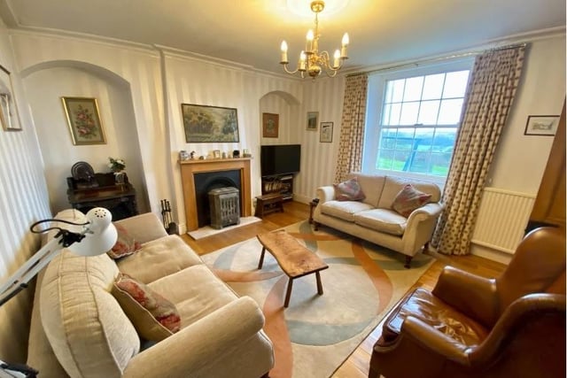 The open fireplace has a cast iron grate with marble hearth and wooden surround and is flanked by arched recesses. This bright and airy room has a large Georgian-style window looking out onto the front of the property and solid oak flooring.