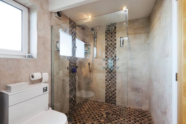 The main bedroom has access to this excellent en suite shower room. It features a double-walk-in shower, his and hers vanity sink unit and low-level WC.