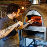 Rickt Marples cooking a pizza in the wood fired oven at Pizza Pi