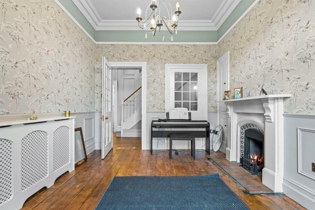 An open fire place, wood panelling to the walls and decorative coving to the ceiling catch the eye.