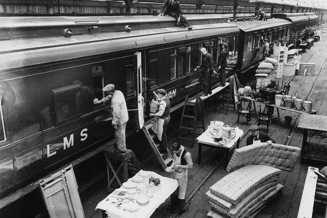 Workmen carrying bedding into a caravan at the London Midland and Scottish Railway works in Derby in readiness for the early season rush, pictured February 23, 1937. (Photo by Hudson/Getty Images)