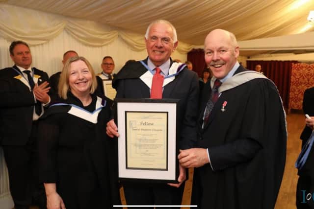 Darryl Claypole, centre, was made a fellow of the Institute of Couriers.