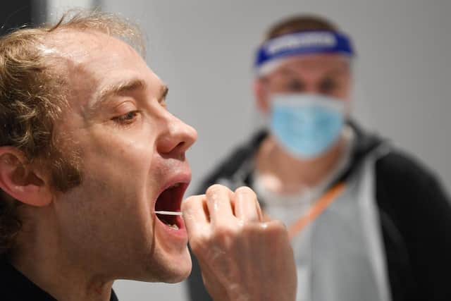 A man takes the lateral flow test. Photo by Finnbarr Webster/Getty Images.