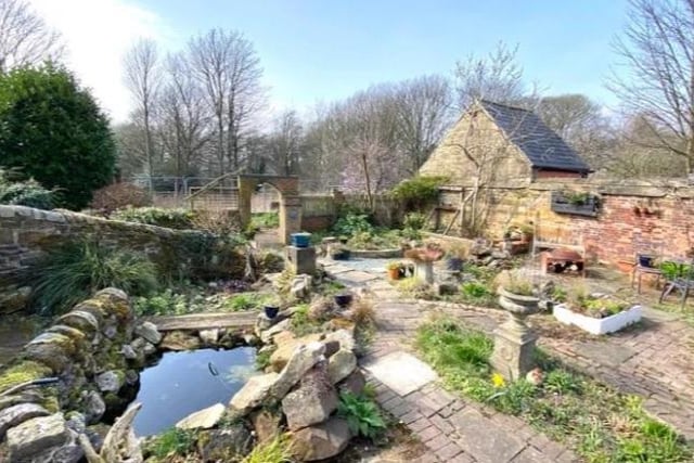 Cottage style rockery areas with a pond, walkways and a brick workshop.